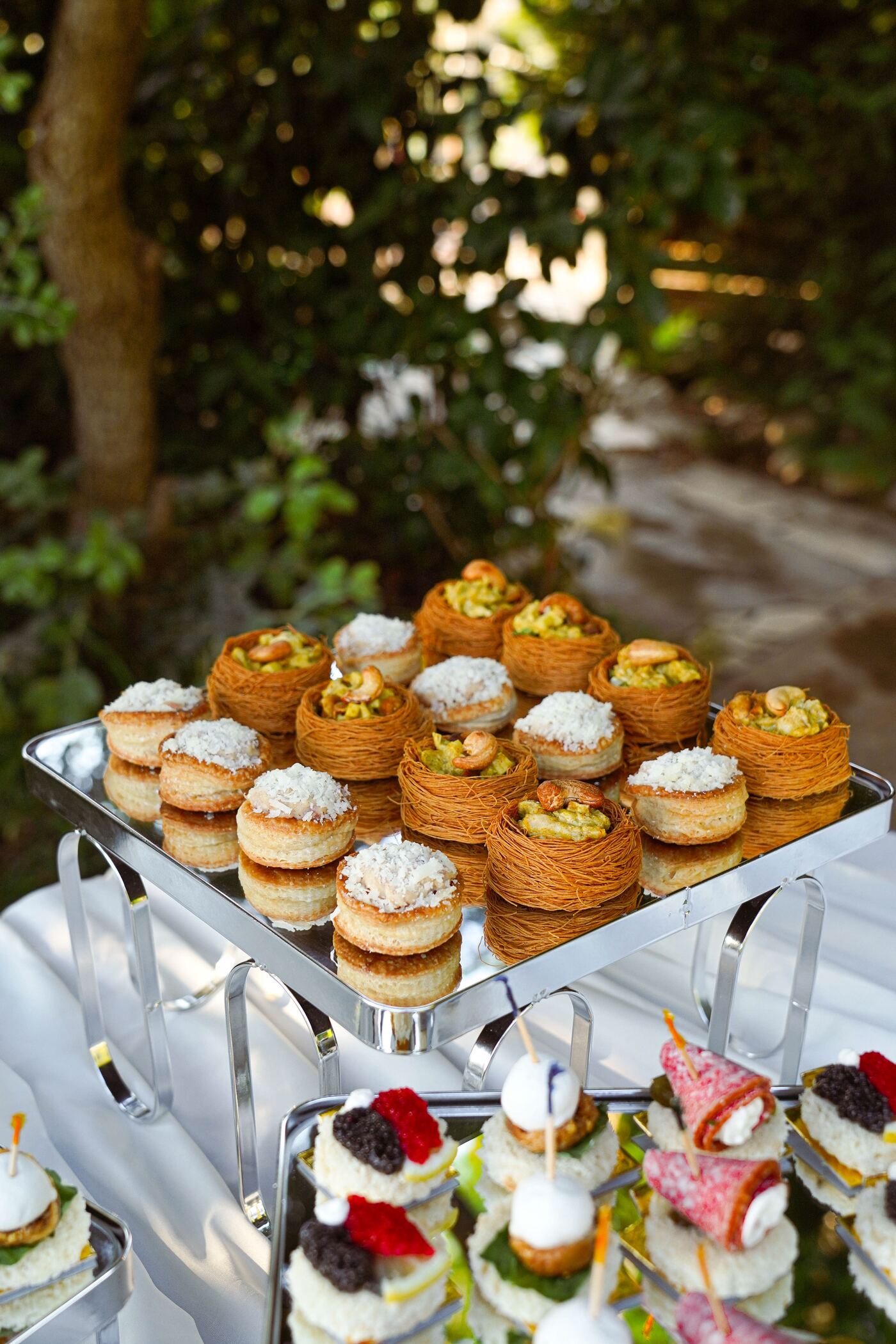 Kataifi nests filled with chicken and cashews beside vol-au-vents on a silver tray